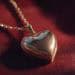 heart-shaped locket on a velvet surface, soft lighting, sentimen