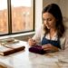 Jeweler examines diamond halo ring at workbench