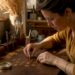 Jeweler designing gold monogram initials at workbench