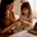 Mother measuring child's finger for adjustable ring