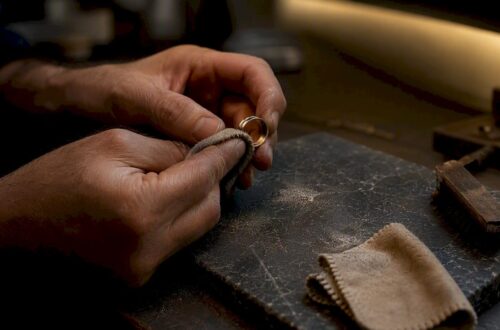 Close-up of hands polishing warm white gold ring