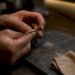 Close-up of hands polishing warm white gold ring