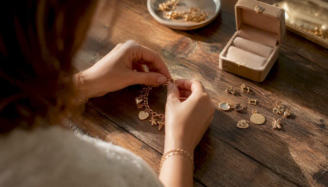 Hands attaching charm to bracelet