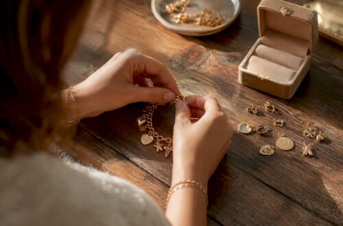 Hands attaching charm to bracelet