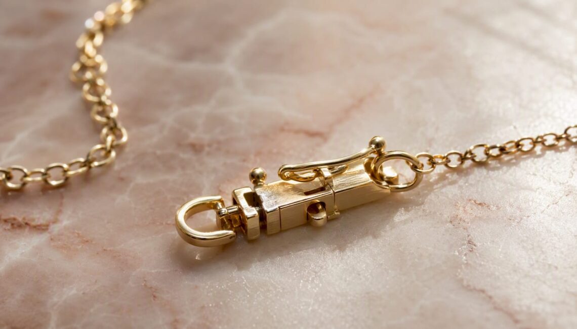 Close-up of child's gold necklace box clasp with safety catch