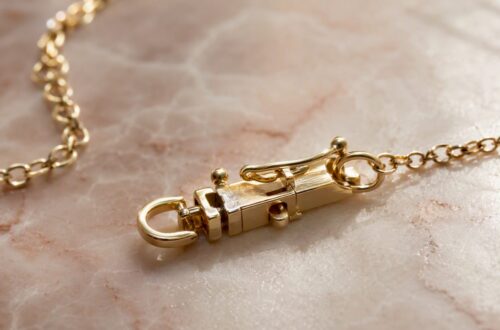 Close-up of child's gold necklace box clasp with safety catch