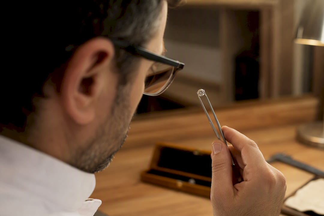 Close-up of hand inspecting diamond clarity