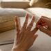 Hands measuring finger size with string at home