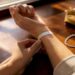 Hands measuring wrist with cloth tape