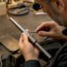 Jeweler resizing gold ring on mandrel