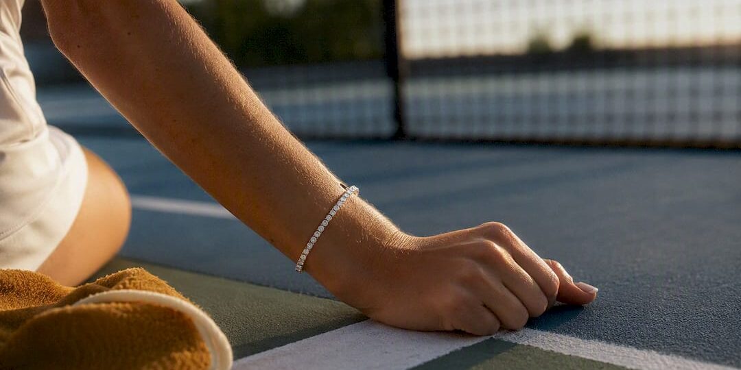 Cropped wrist wearing bracelet on tennis court