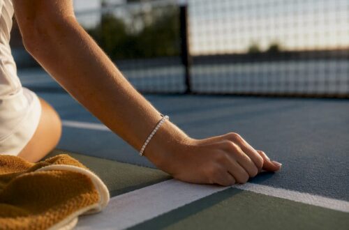 Cropped wrist wearing bracelet on tennis court