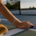 Cropped wrist wearing bracelet on tennis court