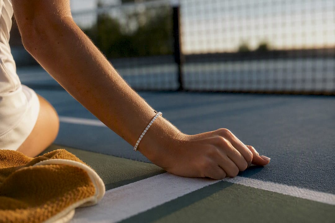 Cropped wrist wearing bracelet on tennis court