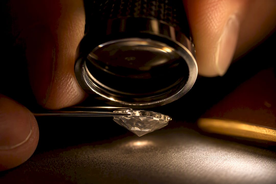 Loupe inspecting a diamond girdle inscription
