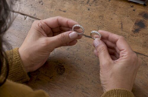 Hands comparing half and full eternity bands
