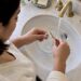Hands gently cleaning a diamond ring at home