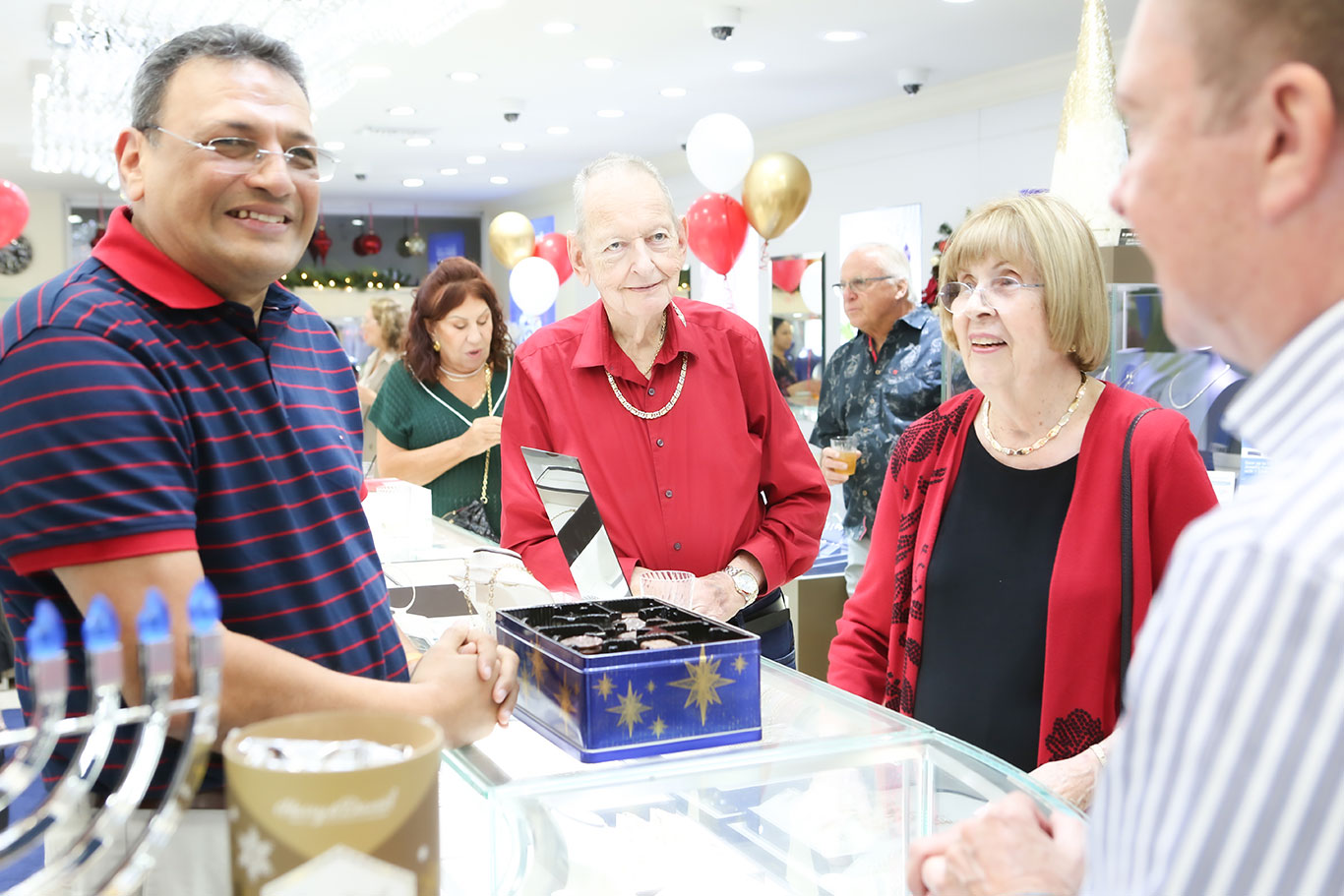 Group of friends socializing at jewelry store holiday event