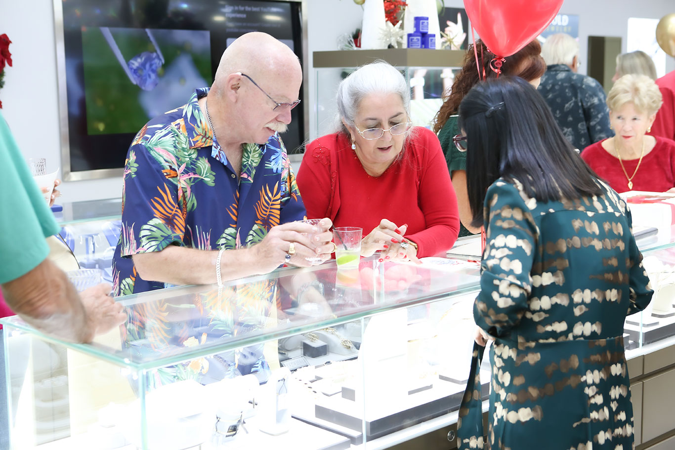 Guests socializing with red and gold balloons at USA Jewels event
