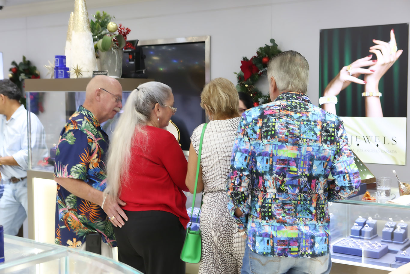 USA Jewels staff helping customer try on jewelry during holiday event