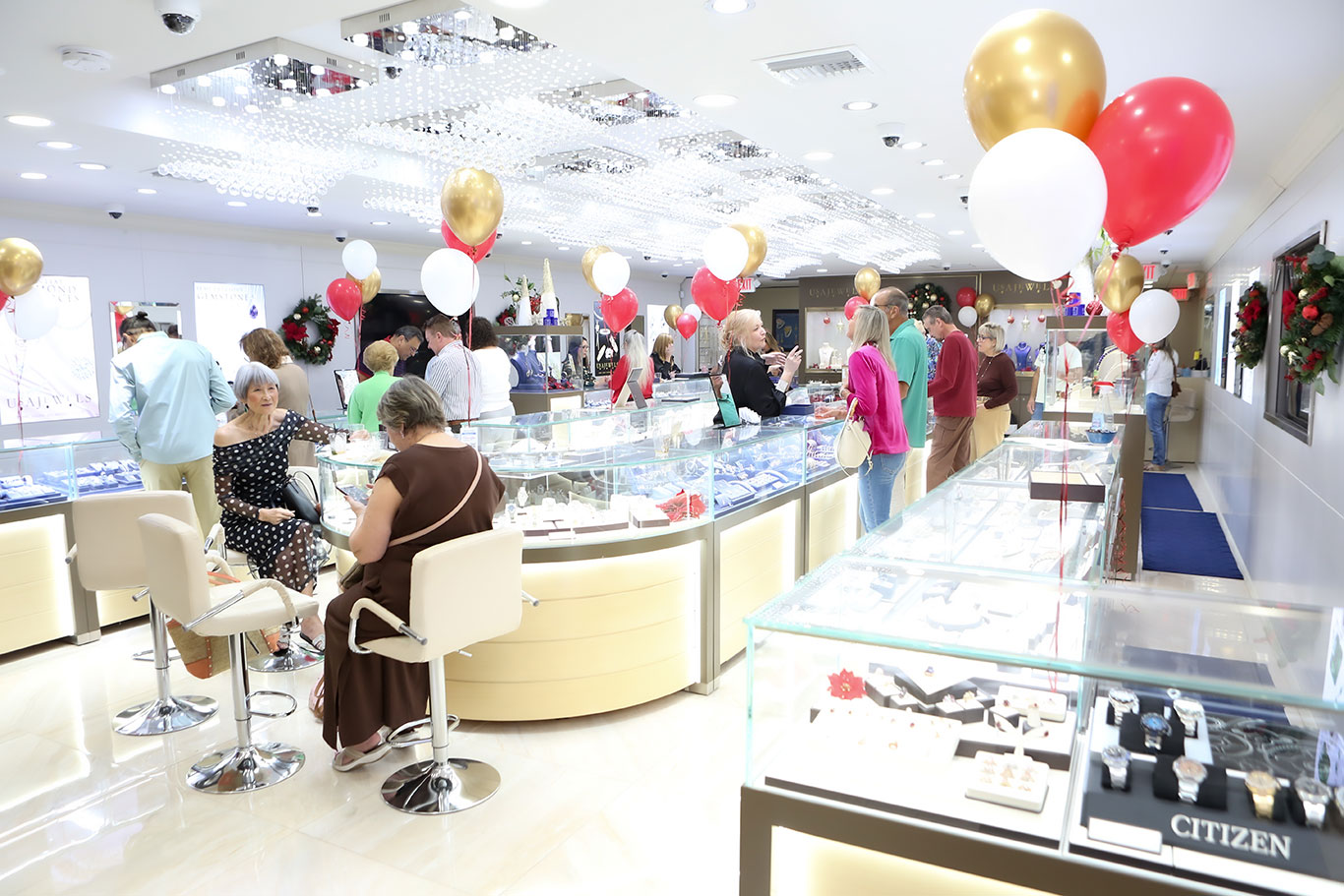 Busy evening at USA Jewels showroom with red, white, and gold balloons