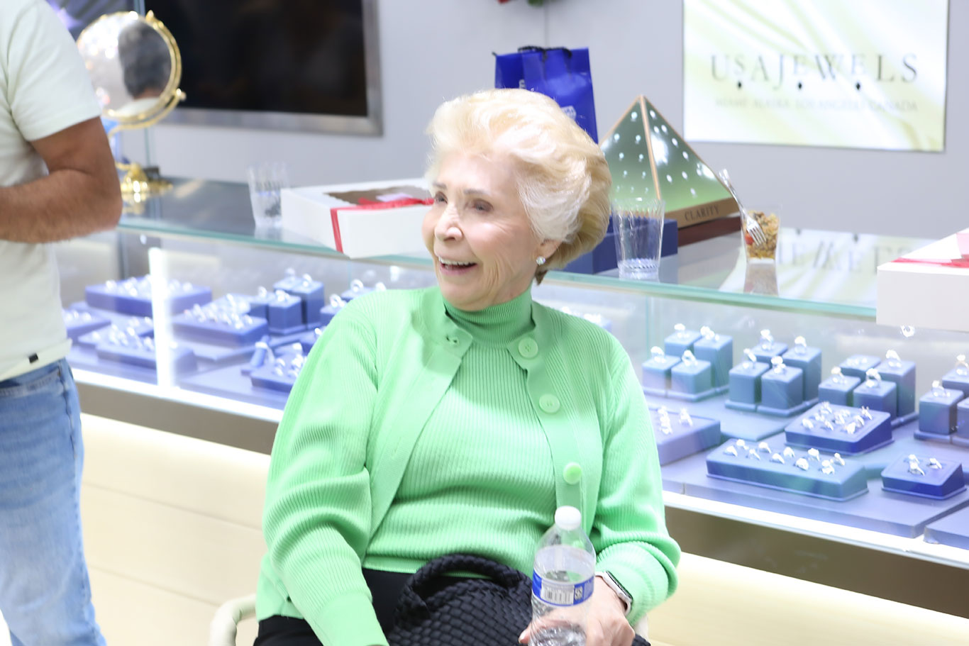 Customer relaxing at USA Jewels holiday open house with jewelry displays